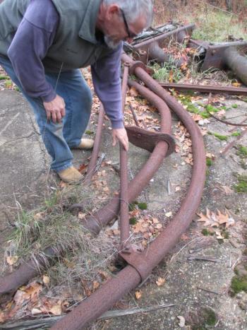 Steve Christiansen, a member of the Wiscasset town crew, examines an iron davit from the Luther Little once used to lower and hoist a lifeboat. PHIL DI VECE/Wiscasset Newspaper davit