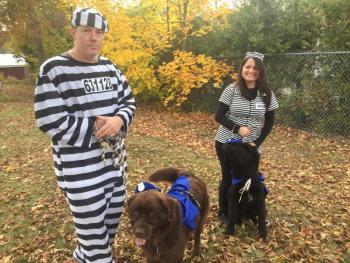 A pair of dogs in badges serve as wardens for Wiscasset’s Herb Leighton and wife and fellow pretend prisoner Loretta Leighton. SUSAN JOHNS/Wiscasset Newspaper