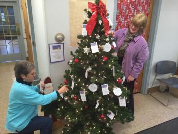 Wiscasset Selectmen’s VIce Chairman Judy Flanagan, left and Wiscasset Administrative Assistant Kathy Onorato place wish tags on a tree in the municipal building. SUSAN JOHNS/Wiscasset Newspaper