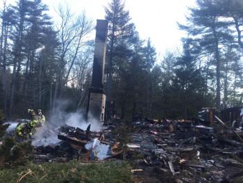 Westport Island firefighters work at an early Friday morning rekindle of the Feb. 25 fire that destroyed a North End Road home, garage and a new Subaru wagon in the garage. SUSAN JOHNS/Wiscasset Newspaper