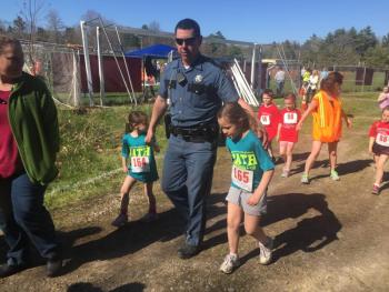 Maine State Trooper James Leonard walks the course with daughters Anna Leonard, 5, left, and Kate Leonard, 6. SUSAN JOHNS/Wiscasset Newspaper