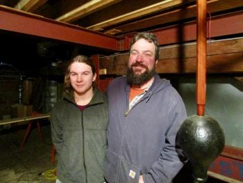 Jason Putnam, right, and son Ivan stand beside the town clock’s pendulum. PHIL DI VECE/Wiscasset Newspaper
