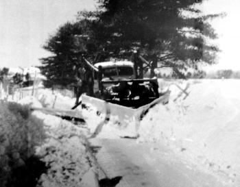 A truck owned by the former Ivan C. Shaw and Sons Construction of Woolwich appears stuck in the snow, its driver on the wing of the plow. The picture was taken near Walker Road possibly in the late 1940s or early 1950s. Courtesy of Jack A. Shaw and Sons Construction