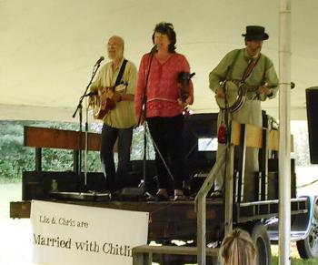Using a 1930 farm truck as a concert stage, “Married with Chitlins” Chris Lannon, left, and Liz Lannon, center, are joined by Tom Albee. JANE CARPENTER/Wiscasset Newspaper