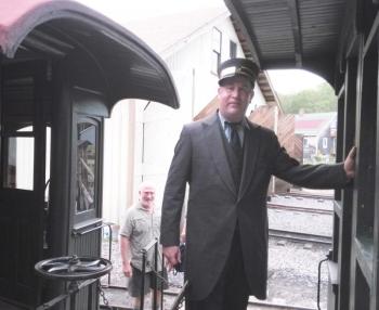 WW&F volunteer conductor Ed Lecuyer welcomes guests aboard the concert series train. JANE CARPENTER/Wiscasset Newspaper