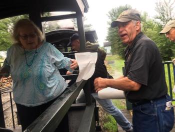 Conductor Bob Cavanagh hands passenger Helen Glickenstein of Philadelphia, Pennsylvania a paper towel for the train car seat. The seats were damp from overnight, he said after handing out the towels during boarding. SUSAN JOHNS/Wiscasset Newspaper