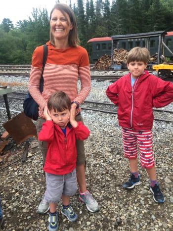 With help from mother Jennifer Moore, Chicago's Gus Moore, 3, cover his ears as they and Gus’s brother Harry, 8, witness a train being prepared for a run. SUSAN JOHNS/Wiscasset Newspaper