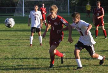 Wolverine Matt Chapman and Lisbon’s Hunter Brissette pursue a loose ball. Chapman netted the game-winning goal for Wiscasset/Boothbay. PHIL DI VECE/Wiscasset Newspaper