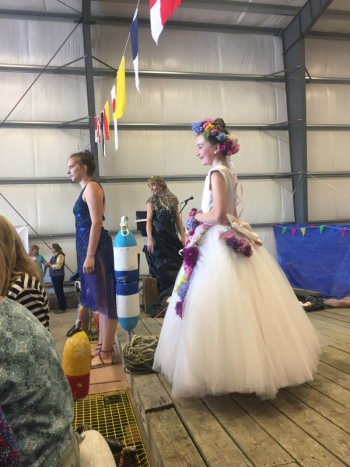 Coastal Maine Botanical Gardens model Maeve Cullina wears a princess’s dream of a dress white, billowy and adorned with flowers (imagine!), Page Brown, center, and Kathleen Sheehan Veins in the background. LISA KRISTOFF/Boothbay Register