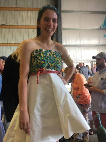 Reagan Cola modeling her own Award-winning design at the 5th annual Fishin For Fashion Show. Created with used shrink wrap (courtesy of Edgecomb Boat Works) and emblazoned with lobster bands in the design of a flower. Along the waist is a reclaimed lobster line found at Morse Mountain in Phippsburg. The shoes are adorned with the same lobster band flowers. To complete the look, Reagan has paired lobster trap jewelry to give the outfit a lobster and nautical- hemed finish. LISA KRISTOFF/Boothbay Register