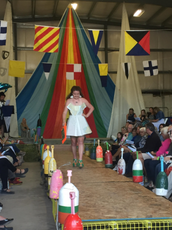 Riley Sullivan in Kathryn Sullivan’s origami skirt and bodice made of nautical charts of the Boothbay region, with green dive bag. LISA KRISTOFF/Boothbay Register