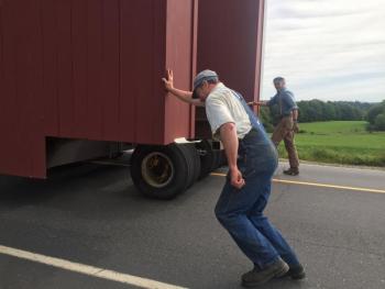 Dana Deering, foreground, pretends to be pushing the 30-ton bridge as he and fellow museum volunteer Steve Lennox, smiling, trail it. At this point Saturday, the bridge was passing the 1789 meetinghouse. SUSAN JOHNS/Wiscasset Newspaper SUSAN JOHNS/Wiscasset Newspaper