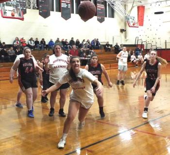 Surrounded by Wolverines, alumna Lindsey Gordon chases after a loose ball in Saturday’s alumni game. PHIL DI VECE/Wiscasset Newspaper