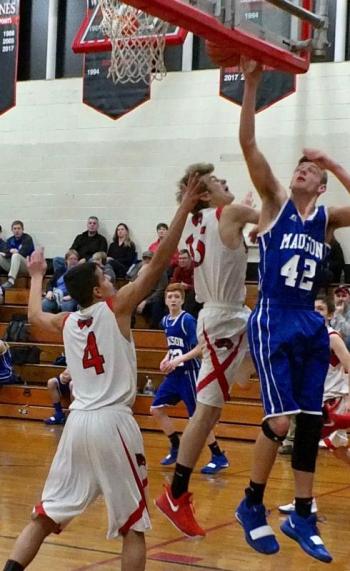 Battle under the backboard. Pictured are, from left, Josh Gabriel, Matt Chapman and Madison’s Thomas Dean. PHIL DI VECE/Wiscasset Newspaper
