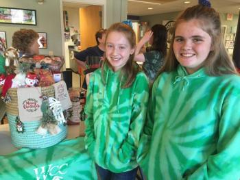 Wiscasset Community Center Unsinkables swim team members Emily Gilliam, left, and Linnea Andersson help man a gift basket fundraiser for the team Dec. 1 in the WCC lobby. SUSAN JOHNS/Wiscasset Newspaper