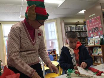 Wiscasset's Jan Whitfield helps Damariscotta's Owen Allen, 7, of Damariscotta prepare a gift downstairs in Wiscasset Publlic Library Dec. 8. SUSAN JOHNS/Wiscasset Newspaper