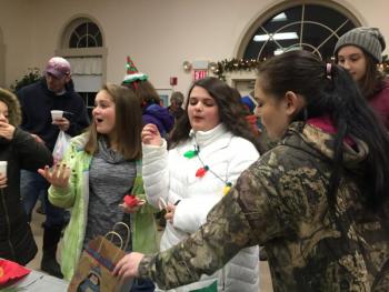 Chorus members Angelina Haggett, center left, and Madison Westrich, center right, who have sung for years at the tree-lighting, enjoy the gathering in the church's fellowship hall after Saturday's ceremony. SUSAN JOHNS/Wiscasset Newspaper