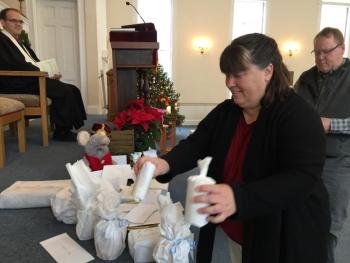 Tammy Doughty leaves white gifts at the manger inside First Congregational Church of Wiscasset Jan. 6. SUSAN JOHNS/Wiscasset Newspaper