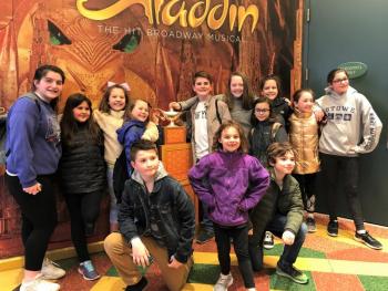A handful of the Y-Arts Youth Travelers pose with the Genie’s Lamp from Aladdin on Broadway. Courtesy of Emily Mirabile