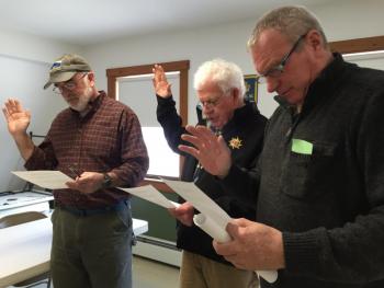From left, newly elected Third Selectman Greg Shute and Second Selectman Doug Baston and newly reelected road commissioner Jeff Verney get sworn in after town meeting. SUSAN JOHNS/Wiscasset Newspaper