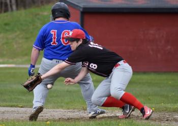 Ouch! A throw over to Wolverine first baseman Billy Pinkham hits Oak Hill’s Casey Dion on the back of his leg. PHIL DI VECE/Wiscasset Newspaper