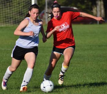 Cara Viele goes shoulder-to-shoulder with an Oak Hill defender. PHIL DI VECE/Wiscasset Newspaper