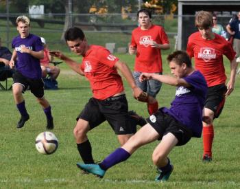 Wiscasset’s Matt Eckert runs toe-to-toe with a Waterville player in the first quarter of Tuesday’s CMSL game. PHIL DI VECE/Wiscasset Newspaper
