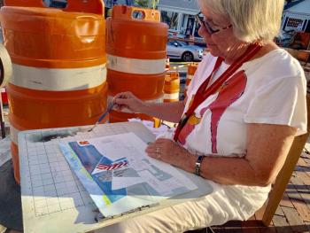 Port Clyde’s Kathleen A. Fox paints in watercolor next to barrels from the state’s downtown project. SUSAN JOHNS/Wiscasset Newspaper