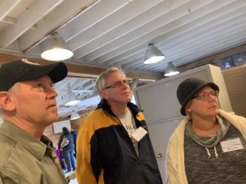 From left, Grover Auto & Tire owner Danny Grover and Wiscasset Woods Lodge owners Eric and Saundra Neperud look at a display of the speedway’s history. SUSAN JOHNS/Wiscasset Newspaper