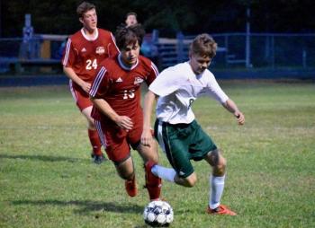 Billy Pinkham and Brian Foye pursue Winthrop’s Adam Hardy. PHIL DI VECE/Wiscasset Newspaper
