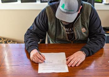 Chad Francis, owner and CEO of Atlantic Landscape Construction, signs the contract to construct the new Veterans Plaza to be located on the northern end of the Lower Mall in downtown Brunswick. Courtesy photo