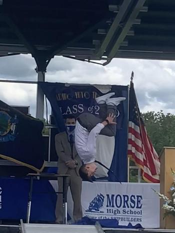 Getting his diploma, a graduating senior does a backflip as Principal Eric Varney looks on. SUSAN JOHNS/Wiscasset Newspaper