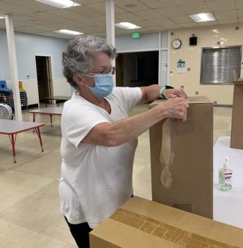 Peg Maguire opens a box. SUSAN JOHNS/Wiscasset Newspaper