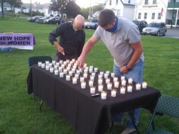 Pastor Peter Ilgenfritz, left, and Brendan McLellan light candles memorializing the 132 Mainers who died from drug overdoses in the past three months. BILL PEARSON/Boothbay Register