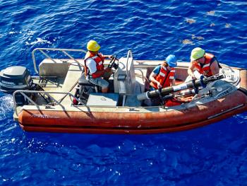 Dr. Meg Estapa, pictured in the blue hardhat, deploying oceanographic equipment from a support vessel while at sea aboard the R/V Atlantic Explorer in the northwestern Atlantic Ocean, near Bermuda. Courtesy of DMC