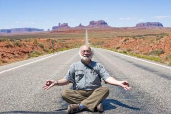 Bob Krist strikes a Buddha, or is it Jerry Garcia, pose to lighten the mood during a video shoot at Monument Valley. Courtesy of Bob Krist