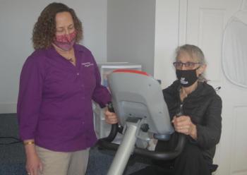 Chamber member Susan Robson tries an exercise machine. ART MAYERS/Wiscasset Newspaper