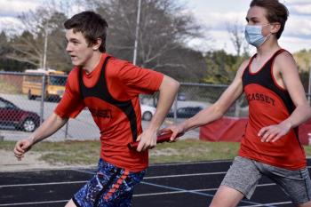 Austin Trask takes the baton from Payton Blagdon in the 4x100-meter relay race at Wiscasset Middle High School May 6. PHIL DI VECE/Wiscasset Newspaper