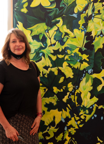 “What inspires artist Colleen Kearney-Graffam? The inter-connectedness of life systems with the natural and perceived mythical worlds. Here she is with her painting, “Look Up.” Photo by Bob Bond Colleen Kearney-Graffam