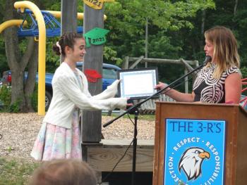 Edgecomb Eddy guidance counselor Haley Bezon presents Charlotte Abello with the school’s academic award June 14 during the sixth grade graduation ceremony. BILL PEARSON/Boothbay Register