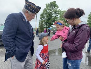 American Legion Post 54’s Wally Pitcher watches as great-granddaughter Claire Allen, 15 months, in mother Maggie Lachance’s arms, offers Pitcher’s great-granddaughter Callie Piecick, 5, a taste of candy after Pitcher and fellow Post members raised the American flag at Wiscasset’s waterfront. SUSAN JOHNS/Wiscasset Newspaper