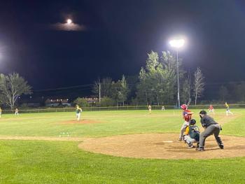 Aidan Sanborn pitches against Mt. Ararat under the lights. The evening was highlighted by a red full moon in the background. Courtesy of Shanon Cotta