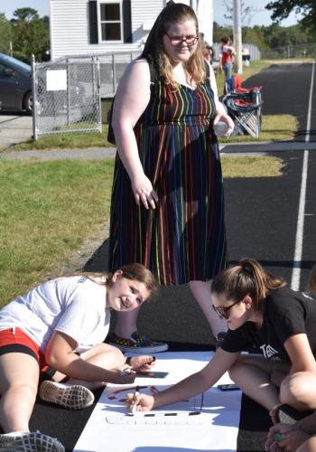 Working on a Wiscasset Middle High School Homecoming spirit poster Sept. 18, from left, are Carolyn Potter, Lindsay Dibert and Myra Pekich. PHIL DI VECE/Wiscasset Newspaper