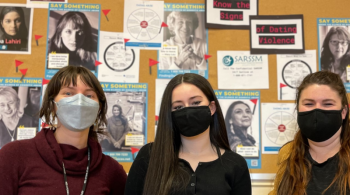 Sophomore Ava Wakem is flanked by social workers Elise Lehotsky and Jaclyn D'Annibale in front of Scarborough High School’s Finding Our Voices display for Teen Dating Violence Awareness and Prevention Month. Patrisha McLean photo