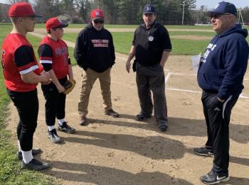 Umpire Ed Crocker held a pre-game conference May 7 with Wiscasset coach Phil DeVice and his team captains Pete Rego, left, and Noah Ruzyckis along with Boothbay Region coach Dennis Dacus prior to the first game between the two schools in four years. BILL PEARSON/Boothbay Register