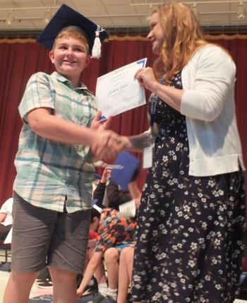 Sixth grade graduate Jackson Zehm receives his diploma from Principal Dr. Christina Boursaw. BILL PEARSON/Boothbay Register