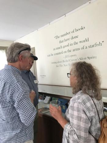 LCHA members Bill Sutter, Jim Kochan, and Kim Dolce talk beneath a displayed quote from Jill Lepore on the influence of Rachel Carson's Silent Spring, "The number of books that have done as much good in the world can be counted on the arms of a starfish." Courtesy photo