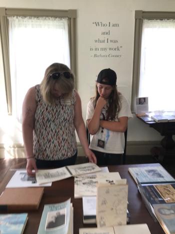 Jeniffer Cooley and Brealynne Phelps browse exhibit materials at the Women Writers of Lincoln County exhibit. Cooley's company Bmalori Creative also provided exhibit sponsorship. Courtesy photo
