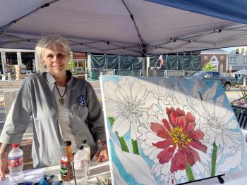 Merrymeeting Adult Education’s Catherine Scanlon, pictured, and Jose Rodriguez invited event goers to help paint this work Scanlon drew. SUSAN JOHNS/Wiscasset Newspaper