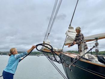 Wiscasset visitor Katy Petersen, left, throws a rope to When and If crew member Luana Santana Aug. 18 when the Wiscasset-built schooner arrived for Schoonerfest. SUSAN JOHNS/Wiscasset Newspaper